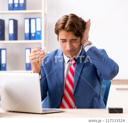 Deaf employee using hearing aid in office 117113524