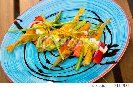Deep fried sprats with creamy ginger sauce, tomatoes, balsamic 117114981