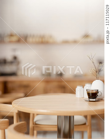 A space for displaying products on a round wooden table in a cozy contemporary coffee shop. 117115029