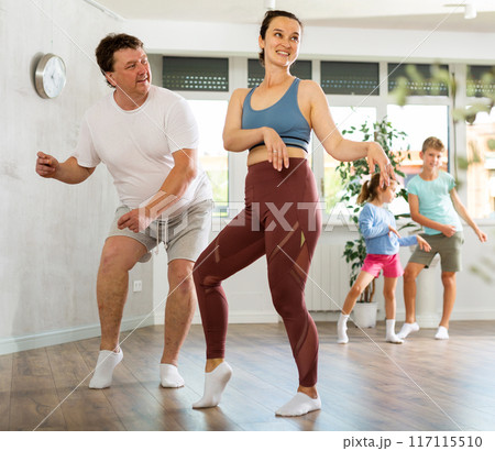 Family with two children dancing in studio 117115510