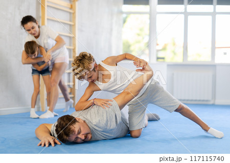 Father teaches his son to use forceful techniques and grips during self defense classes Father teaches his son to use forceful techniques and grips during self defense classes 117115740