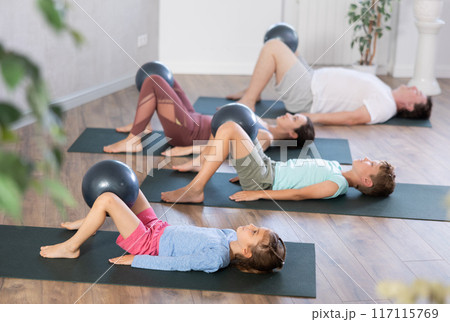 Family with two children doing yoga and pilates using soft ball in gym Family with two children doing yoga and pilates using soft ball in gym 117115769