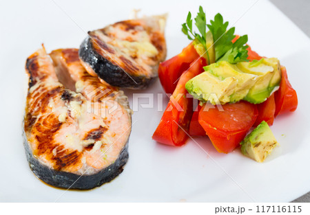 Deliciously steak of fried salmon with tomatoes and avocado on plate 117116115