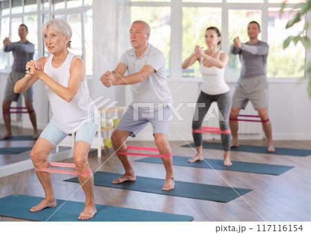 Elderly woman exercises with pilates band 117116154