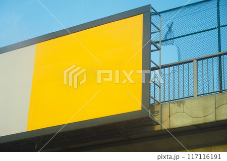 An empty yellow billboard is seen on a highway overpass against a blue sky backdrop An empty yellow billboard is seen on a highway overpass against a blue sky backdrop 117116191