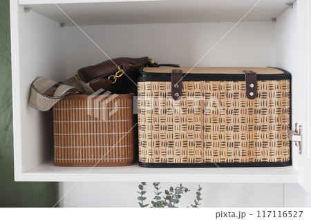 Explore Elegant Storage Woven Baskets and Handbags Beautifully Displayed on a Shelf 117116527