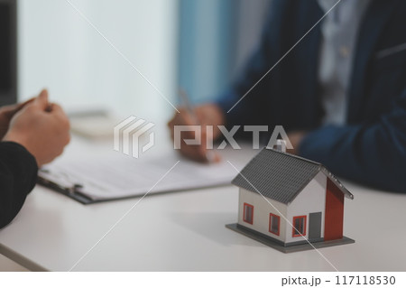 Estate agent giving house keys to client after signing agreement contract real estate with approved mortgage application form, concerning mortgage loan offer for and house insurance. 117118530