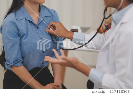 Asian doctor is using a stethoscope listen to the heartbeat of the elderly patient. 117118568