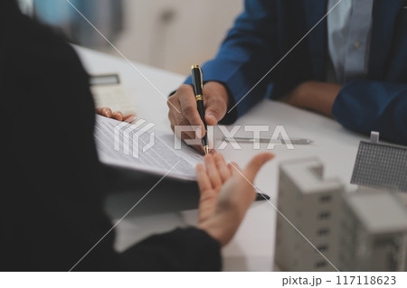 Sale representative offer house purchase contract to buy a house or apartment or discussing about loans and interest rates 117118623