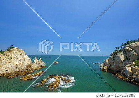 rocky beach scenery with ocean horizon 117118809