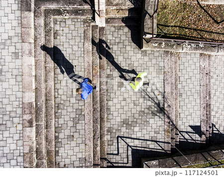 Aerial view of two runners running up the staris in the park. Morning running training for male friends. 117124501