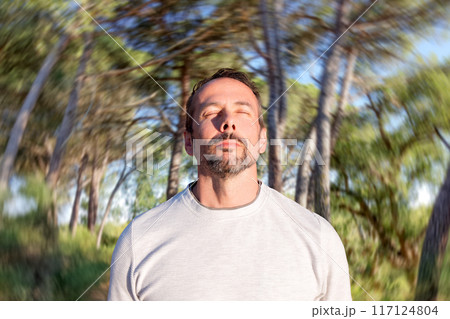 Man standing in a lush green forest 117124804
