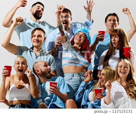 Young emotive people, positive men and women wearing clothes of country, supporting soccer team during match event 117125131
