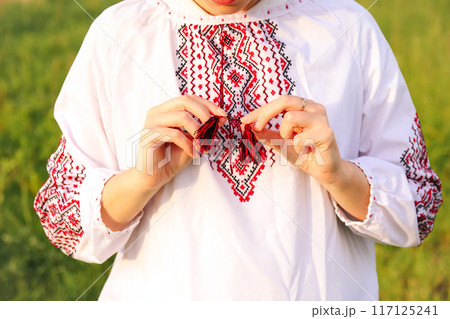 The close-up showcases a woman wearing a vyshyvanka, emphasizing the cultural significance of the embroidery. Embroidery Ukrainian pattern background featuring red and black Ukrainian ornaments The close-up showcases a woman wearing a vyshyvanka, emphasizing the cultural significance of the embroidery. Embroidery Ukrainian pattern background featuring red and black Ukrainian ornaments 117125241