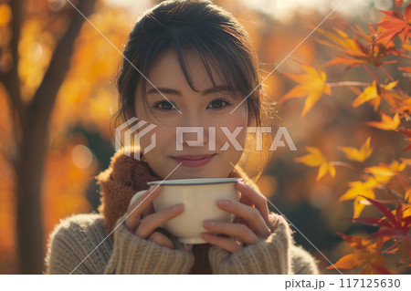秋のカフェでコーヒーカップを持つ女性 117125630