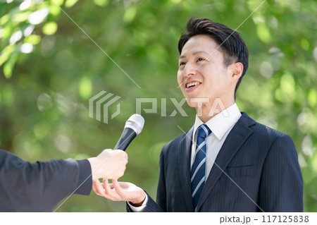 街頭インタビューで熱弁する男性 117125838