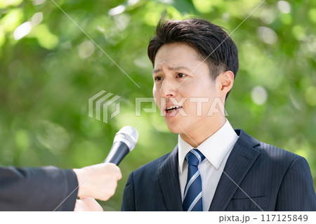 街頭インタビューで熱弁する男性 117125849