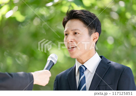 街頭インタビューで熱弁する男性 117125851