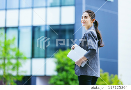 PCを持って歩くビジネスウーマン PCを持って歩くビジネスウーマン 117125864