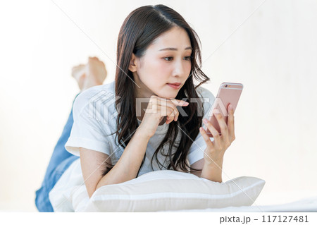 真顔でスマホを見る女性 117127481