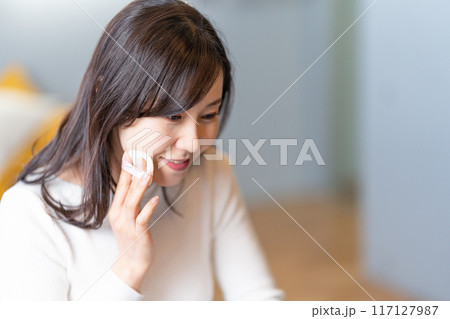 パフを使ってメイクする笑顔の女性 117127987
