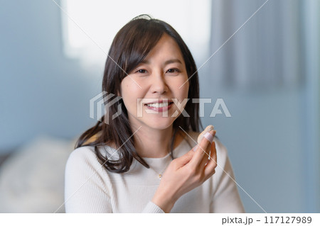 パフを使ってメイクする笑顔の女性 パフを使ってメイクする笑顔の女性 117127989