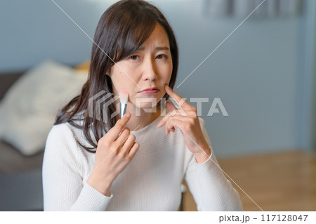 メイクをしながら悩む女性 メイクをしながら悩む女性 117128047