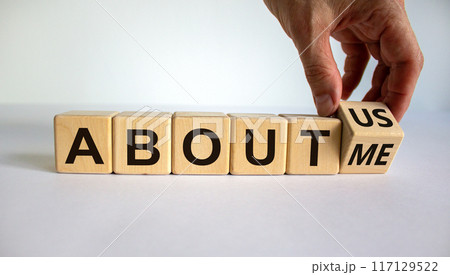 Hand turns a cube and changes the expression 'about me' to 'about us'. Beautiful white background. Business concept. Copy space. Hand turns a cube and changes the expression 'about me' to 'about us'. Beautiful white background. Business concept. Copy space. 117129522