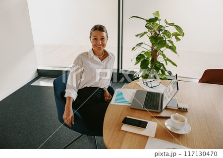 A Professional Woman Engaging in Work Activities Within a Modern Office Environment Setting 117130470