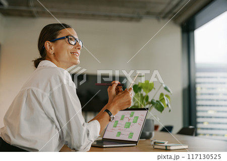 A Professional Woman Working in a Modern Office Environment While Engaging with Her Laptop 117130525