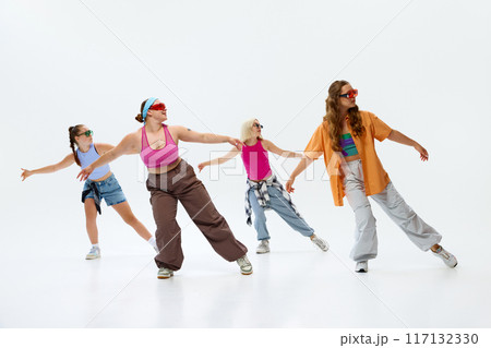 Dancers in colorful outfits and cool sunglasses strike pose, radiating confidence and style against white studio background. 117132330