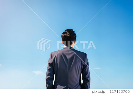 スーツ姿の男性が空を見上げている後姿 117133700