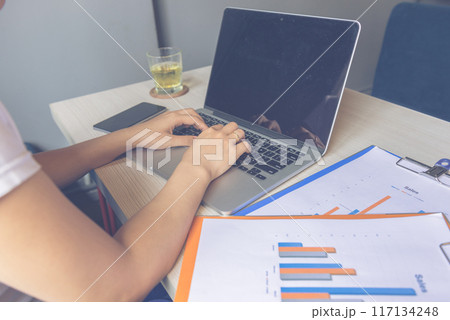 Woman hands typing on laptop about financial report 117134248