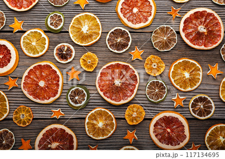 Dried citrus slices with orange peel stars on rustic wooden board 117134695