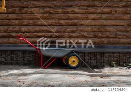 Metal wheelbarrow for trash, garbage, dry leaves. Selective focus, noise. Collection of garbage or harvest in the country Metal wheelbarrow for trash, garbage, dry leaves. Selective focus, noise. Collection of garbage or harvest in the country 117134804