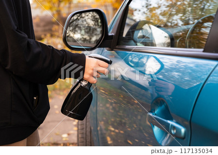 Car disinfection service. A woman disinfects and cleans the inner handle of the car door. Safety and prevention of infection with the Covid-19 virus, infection with microbes or bacteria, wiping clean Car disinfection service. A woman disinfects and cleans the inner handle of the car door. Safety and prevention of infection with the Covid-19 virus, infection with microbes or bacteria, wiping clean 117135034