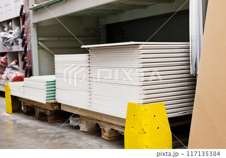 Drywall standard gypsum panels, wallboards plasterboard stacked in hardware store closeup 117135384