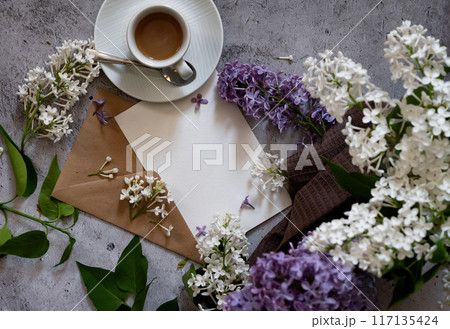 Composition with empty green envelope and beautiful spring lilac flowers on mint background. Mockup card invitation greeting card postcard copy space template. Branches of lilac blooming bouquet. 117135424