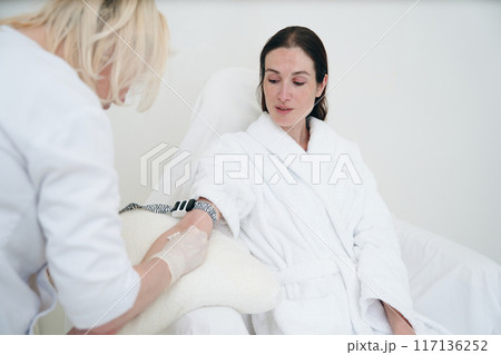 Woman in Spa Robe Receiving Blood Sample at Modern Medical Facility During Daytime 117136252