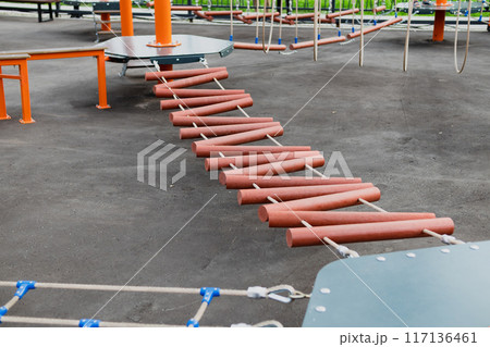 Children Playground with Modern Slide, Rope Net Bridge, Climbing Swings, Climbers. Empty Wooden Playground made of Eco Materials Children Playground with Modern Slide, Rope Net Bridge, Climbing Swings, Climbers. Empty Wooden Playground made of Eco Materials 117136461