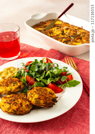 Savor a balanced and appetizing breakfast of zucchini pancakes with fresh lettuce and tomatoes, accompanied by cherry compote and a delightful peach pie 117136553