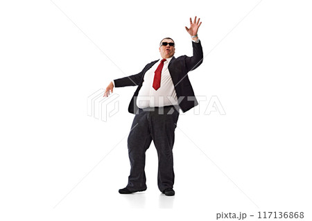 Confident man, businessman in formal wear, black suit and sunglasses, dancing isolated on white background. Positive attitude at work 117136868
