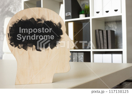 Office and model of head with phrase impostor syndrome. Office and model of head with phrase impostor syndrome. 117138125