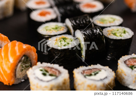 Rolls set with fish shrimp and caviar sushi with chopsticks - asian food and japanese cuisine concept Rolls set with fish shrimp and caviar sushi with chopsticks - asian food and japanese cuisine concept 117140686