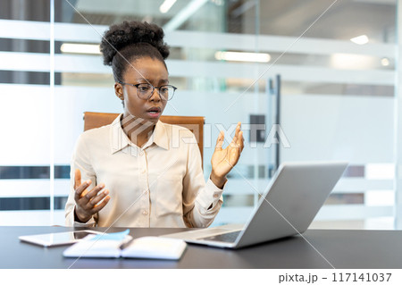 Businesswoman looks frustrated during online meeting in modern office setting. Young professional receiving bad news on laptop, expressing stress and disappointment. Businesswoman looks frustrated during online meeting in modern office setting. Young professional receiving bad news on laptop, expressing stress and disappointment. 117141037