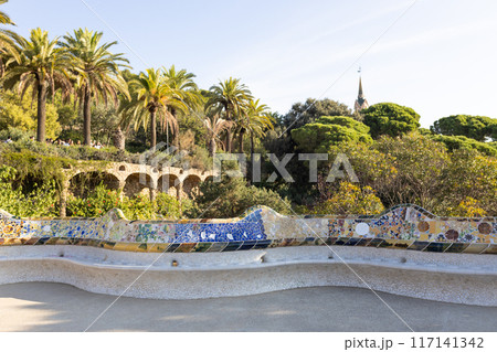 Serpent bench made of mosaic tiles in Park Guell in Barcelona. UNESCO World Heritage Site. Concept of travel, tourism and vacation Serpent bench made of mosaic tiles in Park Guell in Barcelona. UNESCO World Heritage Site. Concept of travel, tourism and vacation 117141342