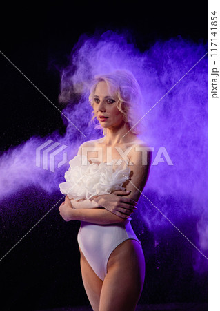 Woman posing with purple particles sprayed in air 117141854