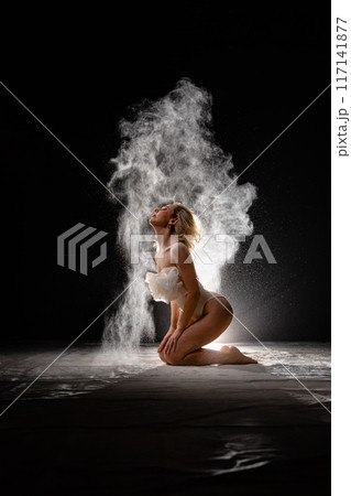 Young slim woman with spread flour on the air 117141877