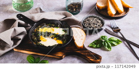 Green shakshuka with basil and green onions in a frying pan on the table web baner Green shakshuka with basil and green onions in a frying pan on the table web baner 117142049