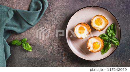 Baked egg and bacon rolls with basil on a plate on a table top view web banner Baked egg and bacon rolls with basil on a plate on a table top view web banner 117142060